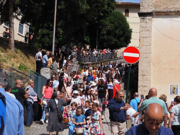 Dopo i muli e i cavalli, i bambini con i cestini di pagnottelle e i mezzi agricoli con travi di legno