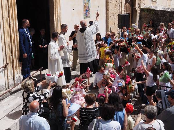 Dopo i muli e i cavalli, i bambini con i cestini di pagnottelle e i mezzi agricoli con travi di legno