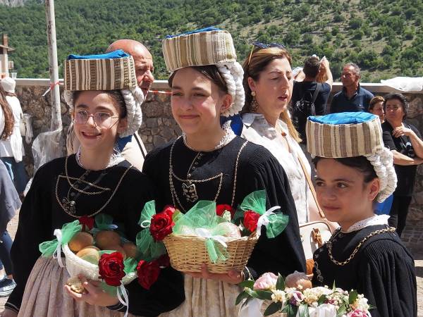 Dopo i muli e i cavalli, i bambini con i cestini di pagnottelle e i mezzi agricoli con travi di legno